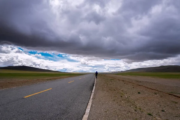 Viaggiare in avanti concetto di sfondo - strada sulle pianure in Himalaya con montagne e nuvole drammatiche . — Foto Stock