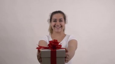 Beyaz tişörtlü beyaz kız hediye kutusunu tutuyor.