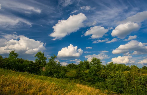 spring clouds and a green field, rural landscape