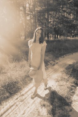 elinde şapka ile güzel kız ormanın zemine karşı olduğunu