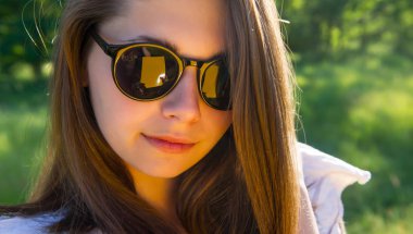 bir kız portresi ormanın bir arka plan üzerinde gözlük düzeltir