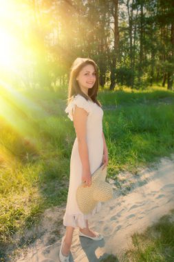 elinde şapka ile güzel kız ormanın zemine karşı olduğunu