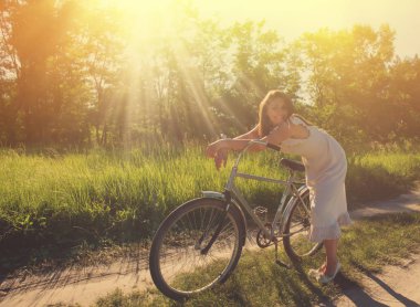 kırsal kesimde bir ormandaki bir bisiklet ile şirin kız