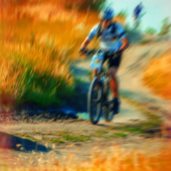 blurred background, a group of sporting cyclists riding on rough terrain