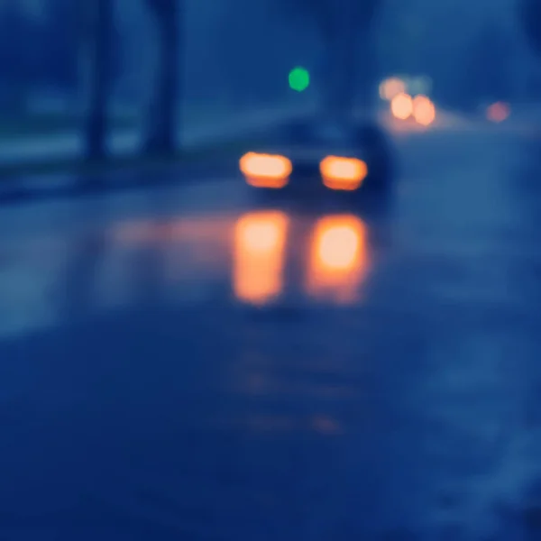 Vehicles driving in the city at night in the rain, blurred background