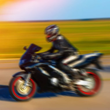 yüksek hızda bir spor motosiklet binici arka plan bulanık, rides