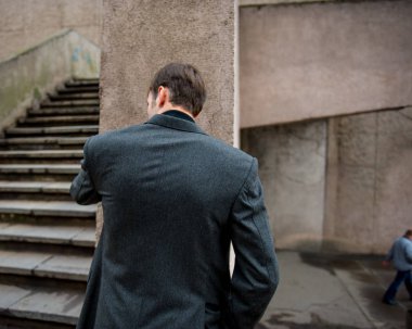 sırtını duvara ve düşünüyor ile ayakta işadamı