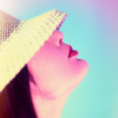 arka plan bulanık, kadın portre dudaklar ve mavi bir arka plan üzerinde bir şapka