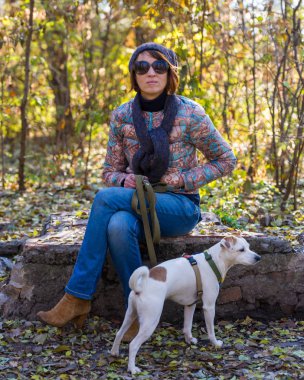 Sonbahar ağaçlar, 40 yaşında bir arka plan üzerinde bir köpek parkı olan bir kadın portresi