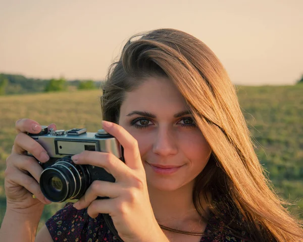 girl in a traveling film camera shoots in nature