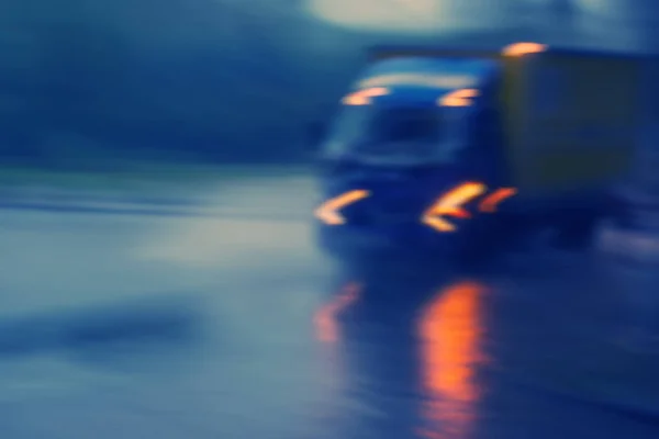 truck driving in the city at night in the rain, blurred background
