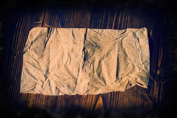 Τσαλακωμένο Φύλλο Από Παλιό Χαρτί Ξαπλωμένο Στο Φόντο Σκούρο Ξύλο — Φωτογραφία Αρχείου