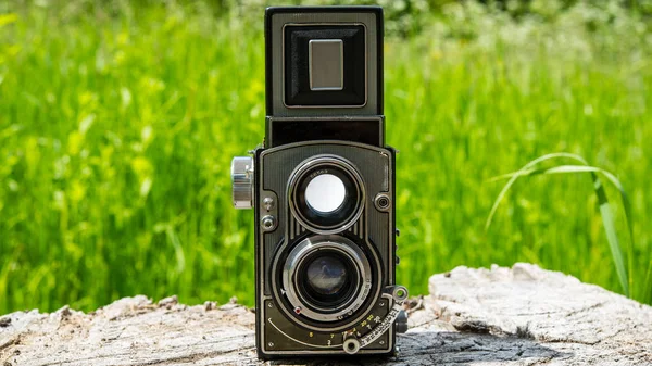 old film camera on a background of green grass