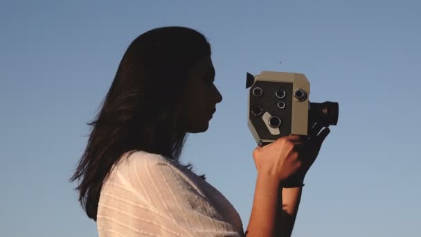 美丽的年轻女子的镜头与老式电影电影相机 — 图库视频影像