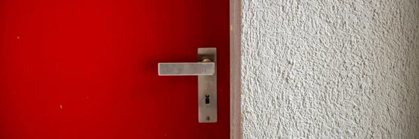 Zavřené kovové dveře s rukojetí a sádroovanou stěnou. — Stock fotografie
