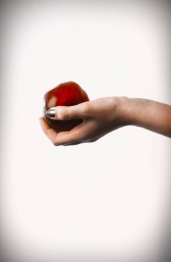 Kadın eli beyaz arka planda kırmızı bir elma tutuyor. Kavram.