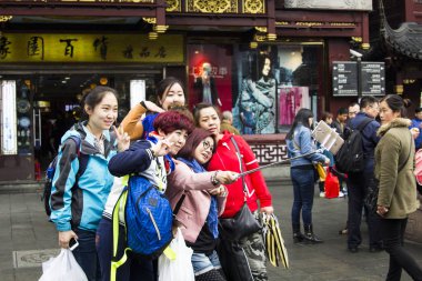 Shanghai, Çin - 28 Mart 2016: Bir grup gülümseyen ve eğleniyor, Shanghai, Çin'in merkezinde selfie fotoğraf selfie sopa yardımıyla yapma Çinli kadın 