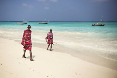 Sahilde, Zanzibar, Tanzanya yürüme geleneksel elbise giymiş iki Masai arkadaş