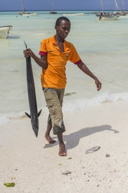 Sahilde büyük balık Zanzibar kamera önünde elinde tutan Afrika balıkçı. Fisherman's gün, Tanzanya catch