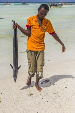 Sahilde büyük balık Zanzibar kamera önünde elinde tutan Afrika balıkçı. Fisherman's gün, Tanzanya catch