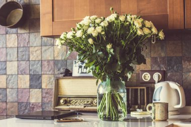 Güzel mutfak beyaz gül buketi. Vintage Radyo ve mutfak gereçleri ve arka plan üzerinde. Vintage filtre fotoğraf