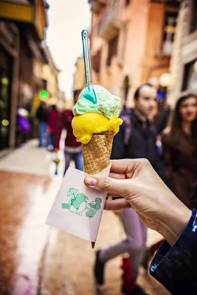 Italian ice-cream in woman's hand close up. Gelato italiano close up.