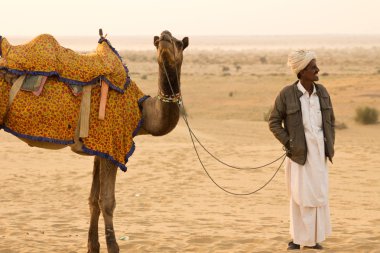 Jaisalmer, Hindistan - Aralık 2015: Rajasthani adam ile onun deve Jaisalmer şehri, Hindistan Thar Çölü'nde 