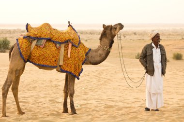 Jaisalmer, Hindistan - Aralık 2015: Rajasthani adam ile onun deve Jaisalmer şehri, Hindistan Thar Çölü'nde 