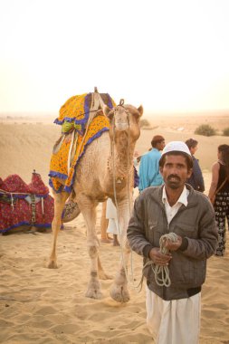 JAISALMER, INDIA - 23 Aralık 2015: Rajasthani adam ve devesi Jaisalmer, Hindistan 'da Thar çölünde