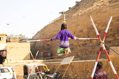 JAISALMER, INDIA - Aralık 2017: Jaisalmer, Rajasthan, Hindistan 'daki geleneksel fuarda Hintli kız halat cambazı (mela)
