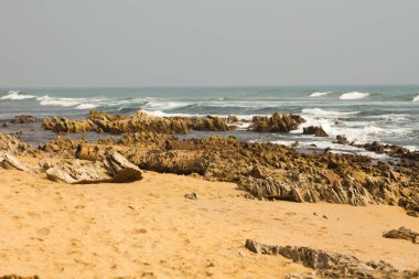 Kumlu deniz sahilindeki kayaların manzarası. 
