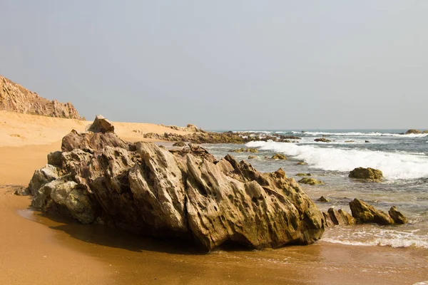 Kumlu deniz sahilindeki kayaların manzarası. 