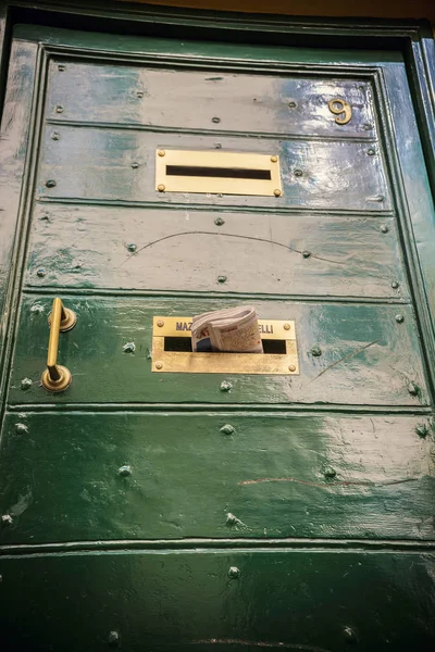 Door in traditional Italian house, mailbox in the Roman house. The newspaper sticks out of the door, Rome, Italy