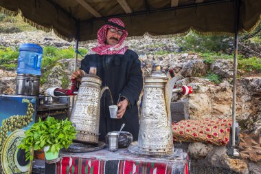 Ajloun, Ürdün - Mart 2019: Bedevi geleneksel olarak Bedevi nane çayı Ajloun, Ürdün için hazırlanıyor giyinmiş adam
