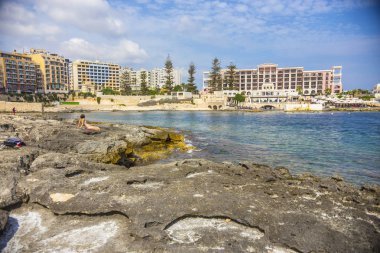 Sliema, Malta sahilindeki insanlar. Stony Sliema plajı
