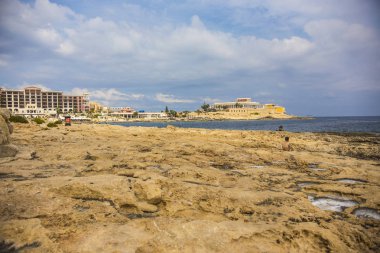 Sliema, Malta sahilindeki insanlar. Stony Sliema plajı