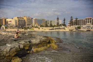 Sliema, Malta sahilindeki insanlar. Stony Sliema plajı