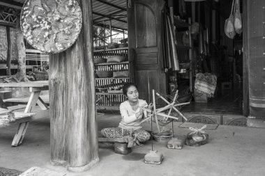 Luang Prabang, Laos - Nisan 2019: Luang Prabang, Laos'ta dokuma makinesinde çalışan Lao kadını