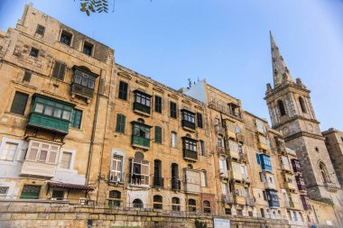 La Valletta, Malta - Eylül 2018: Geleneksel Malta mimarisi, ahşap renkli balkonlu ev ve Kule La Valletta, Malta