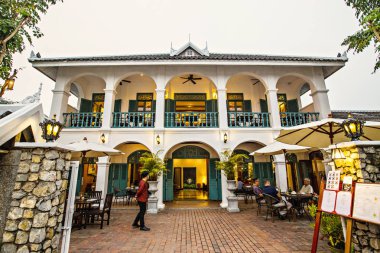 Geleneksel Luang Prabang oteli, beyaz koloni binasında açık hava restoranı ve dışarıda oturan insanlar, Luang Praband, Laos