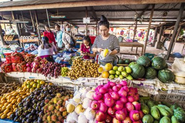 LUANG PRABANG, LAOS - Nisan 2019: Meyve pazarında sulu meyve yığınları: mango, muz, ejderha meyvesi Luang Prabang, Laos