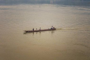Luang Prabang, Laos - Nisan 2019: Gün batımında Mekong nehri üzerinde uzun tekne, Luang Prabang, Laos