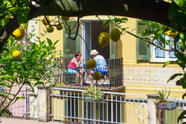 Riomaggiore, İtalya - Haziran 2019: Balkonda kahvaltı yapan çift, İtalyan evi, sarı limonlu limon dalları, Cinque Terre, Liguria, İtalya