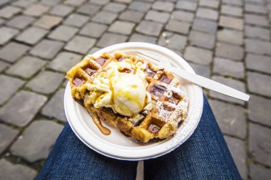 Tabağında dondurma olan Belçika Waffle 'ları bulanık Grote Markt arka planı, Brüksel, Belçika