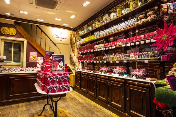 Brüksel, Belçika - Mayıs 2019: Brüksel şehir merkezinde çikolata ve tatlı ların büyük seçenekleriyle geleneksel Çikolata ve şekerleme dükkanı