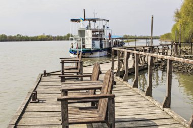 VILKOVO, UKRAINE - Nisan 2018: Tahta iskele ve Tuna Nehri üzerindeki tekne, Vilkovo, Ukrayna