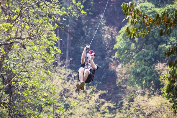 LAOS - Nisan 2019: zip hattında ormanda bir adam. Laos ormanında halatla kayma, Gibbon macera turu, Laos