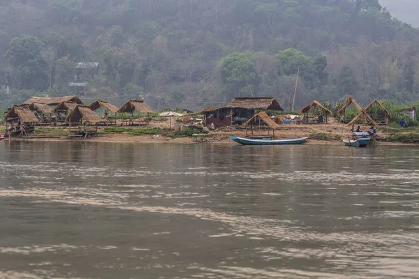 Luang Prabang, Laos - Nisan 2019: Sahilde küçük köy evleri ile Mekong nehri üzerinde güzel gün batımı, Luang Prabang, Laos