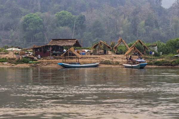 Luang Prabang, Laos - Nisan 2019: Sahilde küçük köy evleri ile Mekong nehri üzerinde güzel gün batımı, Luang Prabang, Laos
