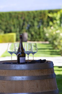 KELOWNA, CANADA - Eylül 2019: şarap şişesi ve tahta fıçının üzerinde dört bardak. British Columbia, Okanagan Lake Valley, Kanada 'daki Mission Hill Aile Estate Şaraphanesi